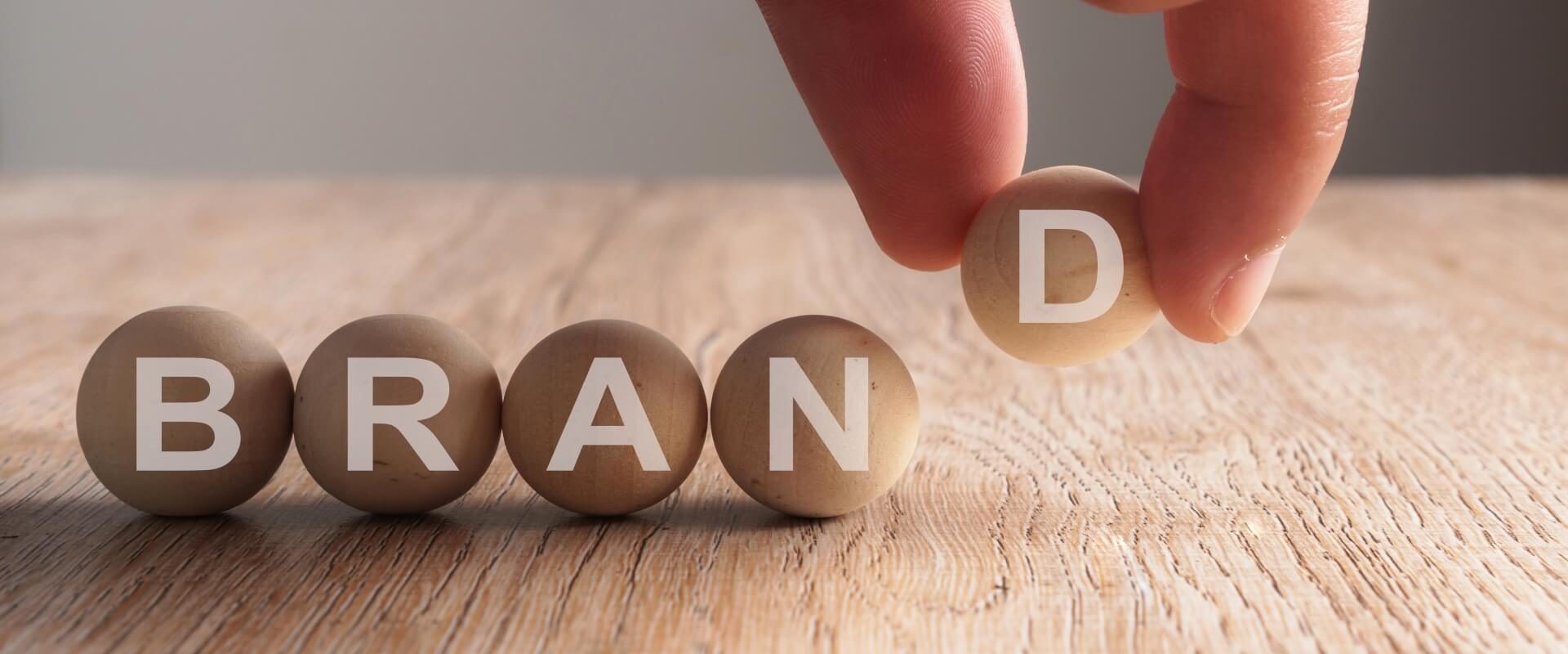 hand-putting-brand-word-written-wooden-ball2 (1)